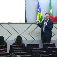Dr. Lucas Velasco apresentando informações no telão do Auditório